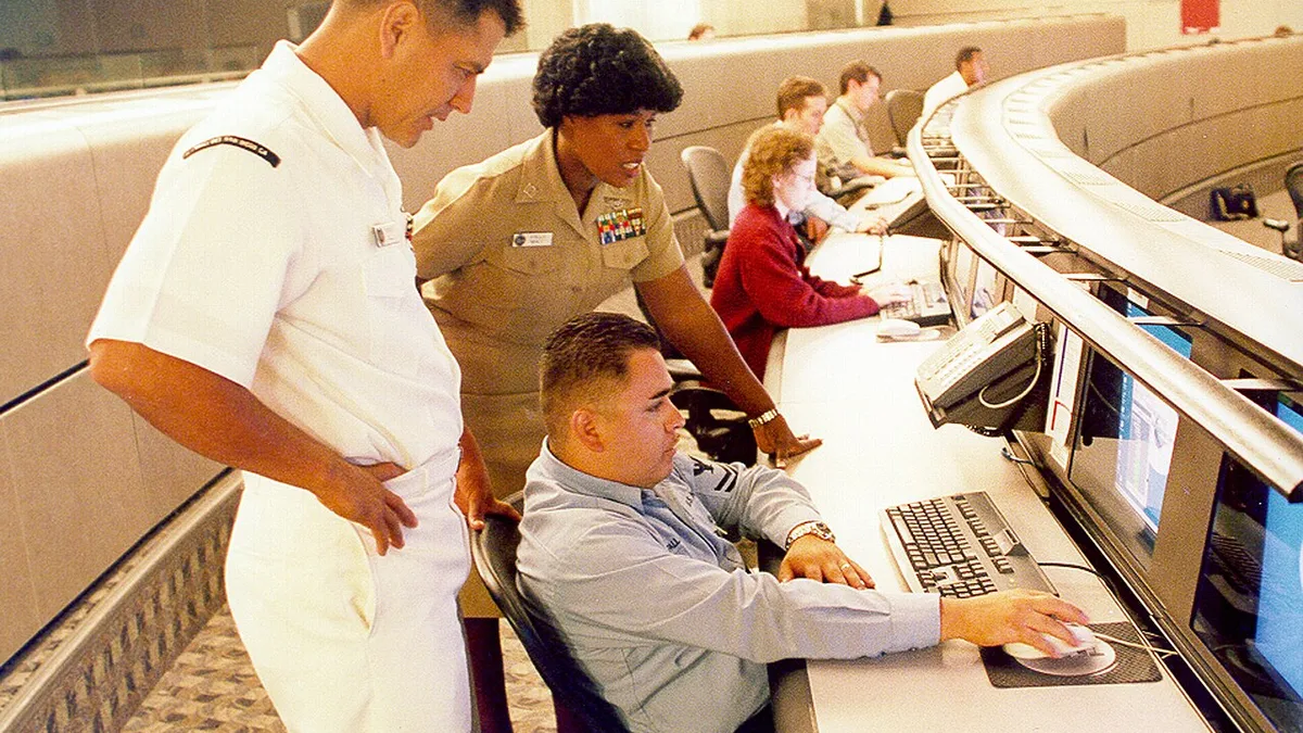 US Navy 040614-N-7952W-001 Information Systems Technician 1st Class Thomas Dull, left, Lt. Stella Nealy, center, and Information Systems Technician 2nd Class Eduardo Pallanes study a computer monitor at Naval Network and Space