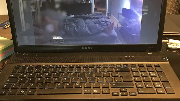 Sony Vaio Laptop showing video with man lying in bed watching TV