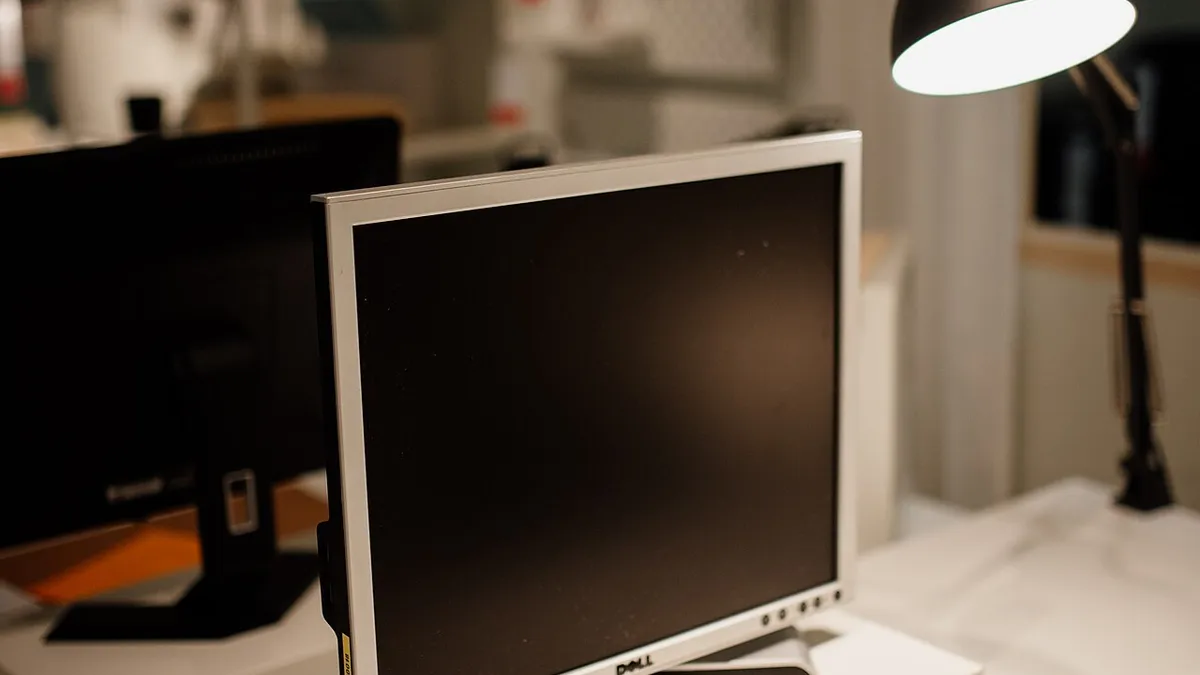 Workspace setup with a computer monitor and desk lamp in an office environment