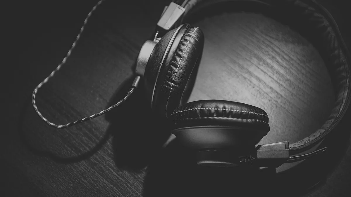 Headphones on wood in black and white (Unsplash)