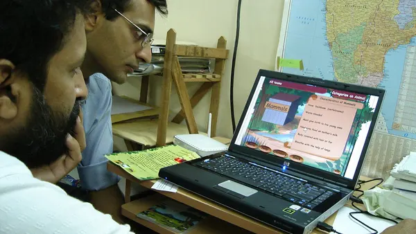 Indian men behind a laptop computer