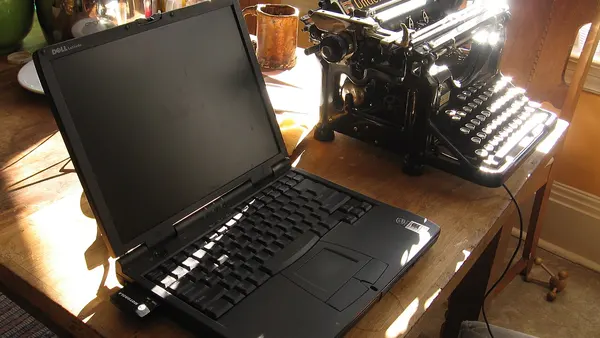 A laptop and a typewriter