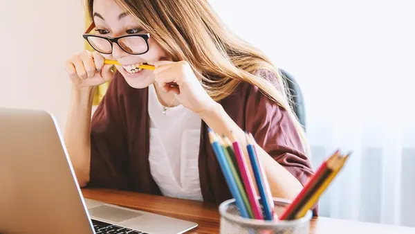 Laptop and girl biting pencil-pixabay