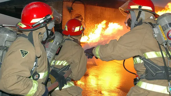 US Navy 060502-N-4565G-007 Aviation Electronics Technician 1st Class Jason Rouse, team leader of a shipUs repair locker, directs his hose team to advance on the Mobile Aircraft Firefighting Training Device (MAFTD) aboard USS Jo