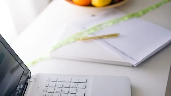 Doctors computer, notebook and fruit on the table