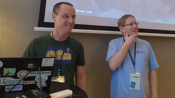 Sam Wilson and VIGNERON at Wikimedia Hackaton 2024 - with laptop full of stickers
