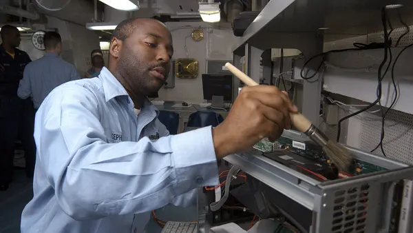 US Navy 040719-N-7748K-015 Information Systems Technician 2nd Class Mark Cephus of Atlanta, Ga. cleans dust off of a computer aboard USS Enterprise (CVN 65)