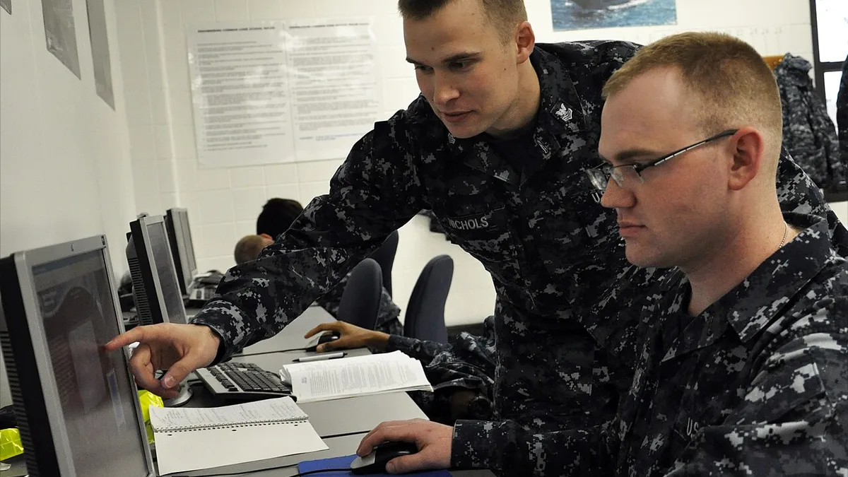 US Navy 111026-N-ZZ447-003 Hull Technician 1st Class Nolan R. Nichols answers a question on the computer-based training system
