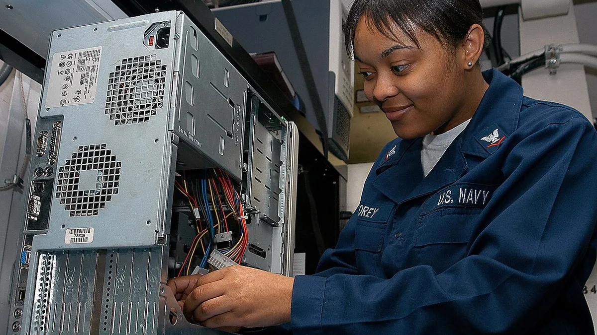 US Navy 040418-N-1522S-007 Information Systems Technician 3rd Class Lakita Corey, of Williamston, N.C., fixes a computer